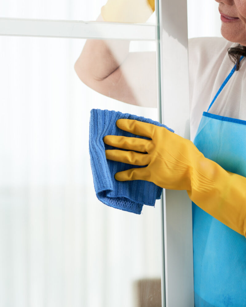 cropped-woman-cleaning-window-wearing-special-apron (1)